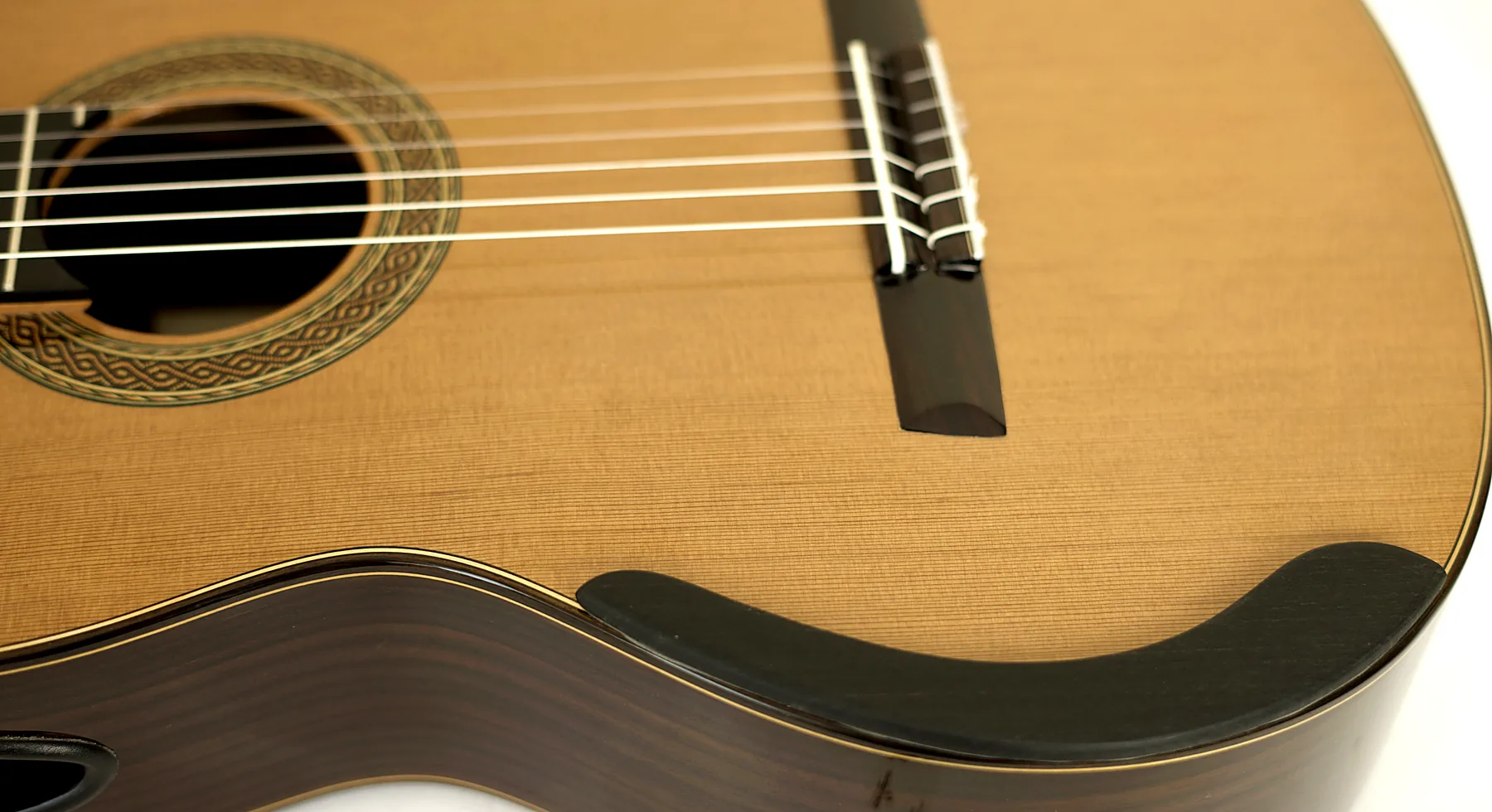 Contoured ebony armrest on the lower bout of an Arrius classical guitar